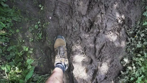Hiking boots walking through mud on a footpath Stock Footage 133434743