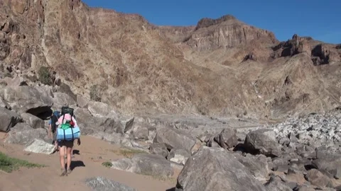 Hiking at the bottom of a large canyon Vídeos de archivo 146594934