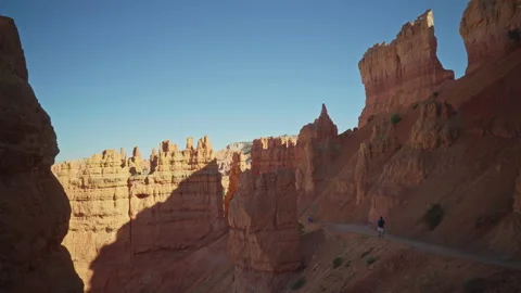 Hiking at Bryce Canyon at sunset between large red rocks Video stock 208957955
