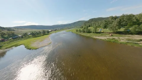 Hiking camping on one side of the river and a small village on the other. Bright Stock Footage 158304100