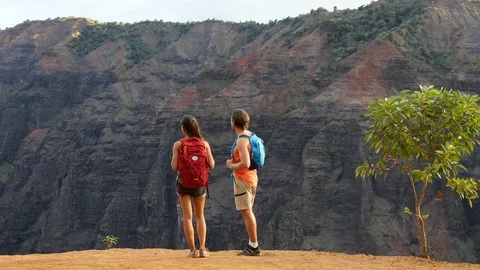 Hiking couple looking at view during hike in Waimea Canyon Stock Footage 73372390