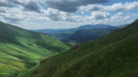 Hiking up from Grassmere the view across rolling hills of the Lake District Stock Footage 157679776