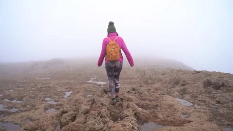 Hiking group ascend to Roque Nublo in a misty morning with fog Stock Footage 231789900