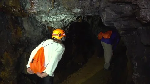 Hiking Group Bending to Enter Dark Tunnel in Abandoned Mine - 16 Video stock 308401488