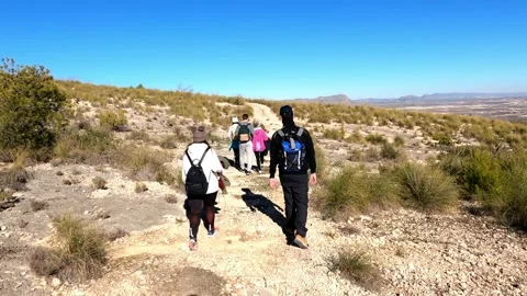 Hiking group walking through path in mountain top against beautiful landscape Stock Footage 146363886