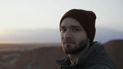Hiking hobby. Alone man backpacker in red hat looks at the camera Stock Footage 145738053
