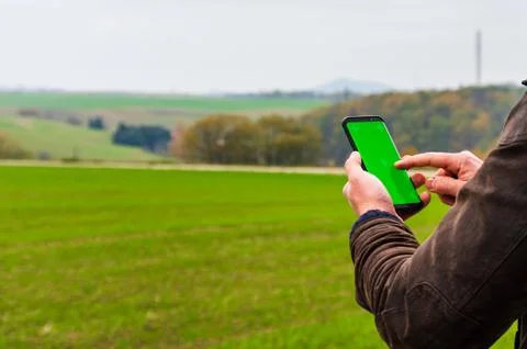 Hiking man with leather jacket using his smart phone to navigate  Stock Photos