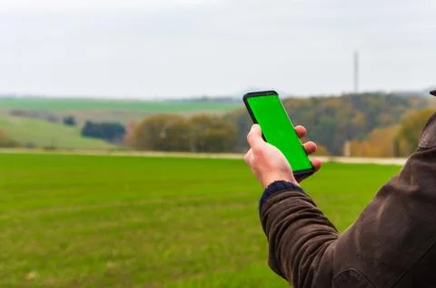 Hiking man with leather jacket using his smart phone to navigate  Stock Photos