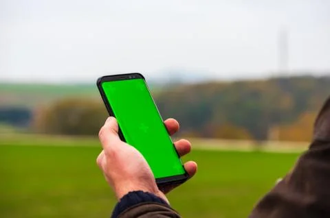 Hiking man with leather jacket using his smart phone to navigate  Stock Photos