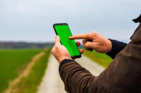 Hiking man with leather jacket using his smart phone to navigate  Stock Photos