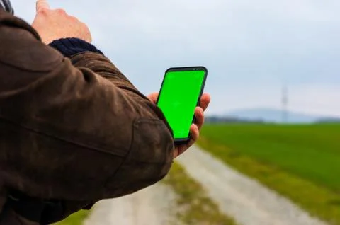 Hiking man with leather jacket using his smart phone to navigate  Stock Photos