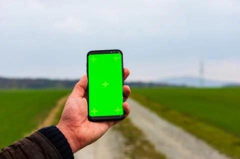 Hiking man with leather jacket using his smart phone to navigate  Stock Photos