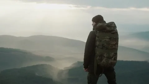 Hiking man in mountains, with beautiful view of mountains with sun rays Stock Footage 317214927