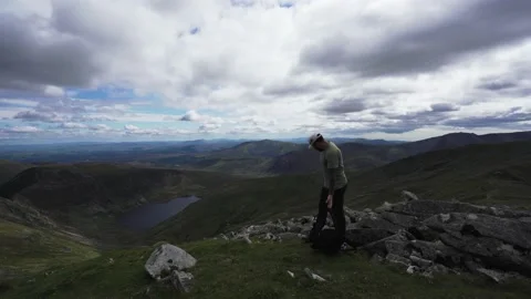 A hiking man taking a rest high in the mountains Vidéo 139957627