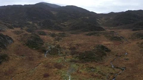 Hiking man through brown winter mountain landscape 動画素材 168733269