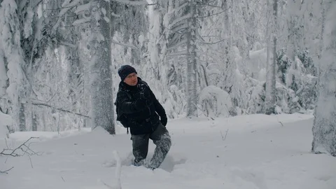Hiking man walks through deep snow in winter forest and shooting self video Stock Footage 122999268