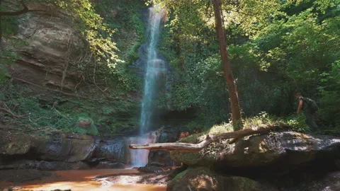 Hiking man with a waterfall in the middle of the forest Stock Footage 131013551