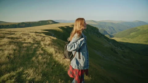 Hiking on a mountain path during a sunny day in the countryside with a person Stock Footage 345638181