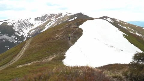 Hiking on a mountain trail with snow in the background. Spring Hiking Video stock 328095299