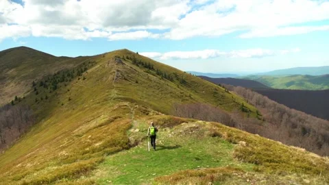 Hiking on the mountain trail in spring with clear sky and green hills Stock Footage 327139278