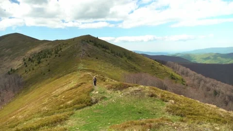 Hiking on the mountain trail in spring with clear sky and green hills Stock Footage 328095292