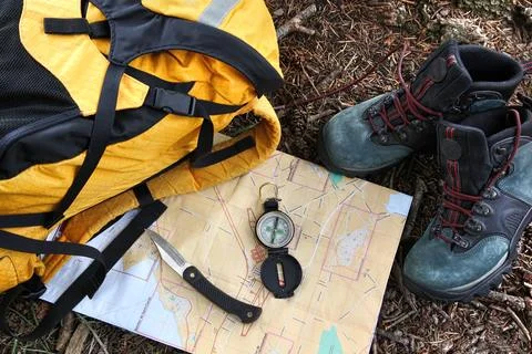 Hiking shoes on map with compass Stock Photos