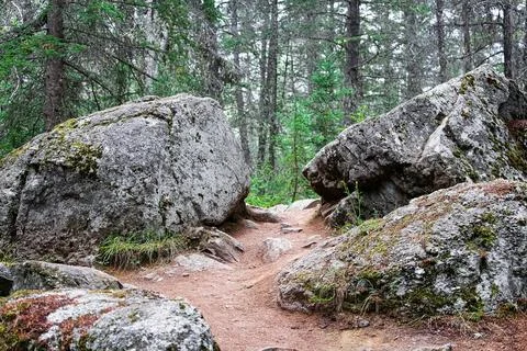A hiking trail between two large boulders Stock Photos
