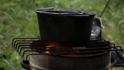 In a Hiking trip in a pot over the fire preparing food Stock Footage 112620920