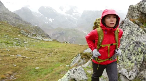 Hiking - woman hiker backpack trekking in rain on mountain Stock Footage