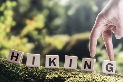 Hiking word text on cubes on a forest background. Man walking, mountain tourism Stock Photos