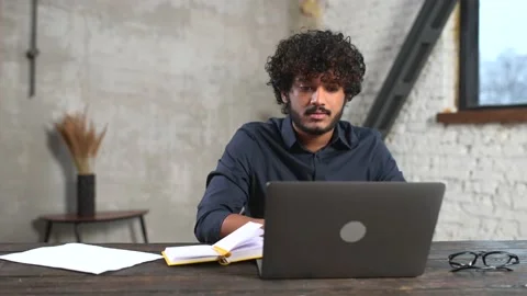 Hilarious Indian guy using laptop for remote video connection Stock Footage