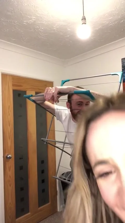 Hilarious moment man gets stuck in clothing rack in hilarious TikTok gone wrong Video stock 272914634