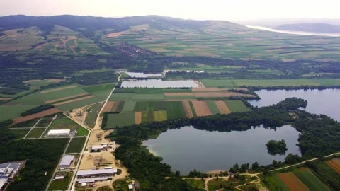 A hill on a horizon covered with square fields and and lakes at foothill Stock Footage 269165709