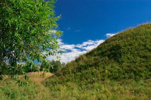 The hill in the middle of meadows Stock Photos
