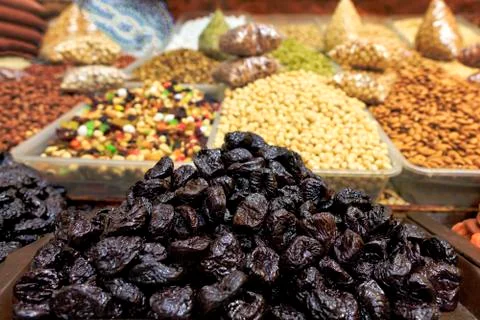 Hill of prunes on the background of various nuts in a blur. Stock Photos