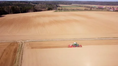 On a hill, a tractor plows the fields 動画素材 172377823
