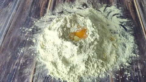 A hill with wheat flour and an egg inside is sprinkled Stock Footage 232219588