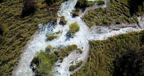 A hill with winding rocky paths in every direction surrounded by colorful nature Stock Footage 112384339