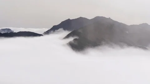 Hills emerging from low clouds Stock Footage 124076409