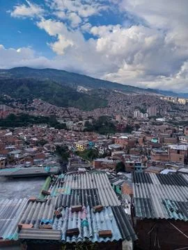 Hillside Cityscape With Dense Rooftops &amp; Dramatic Sky Over A Mountain Stock Photos