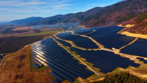 Hillside solar panel array stretching across mountain valley in autumn. Warm Stock Footage 336783310