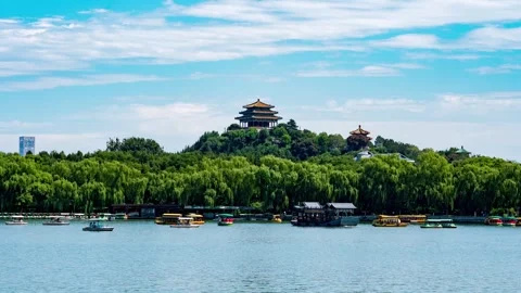 Hilltop pavilions above willow lined water and small boats in Beijing Stock Footage 346572233