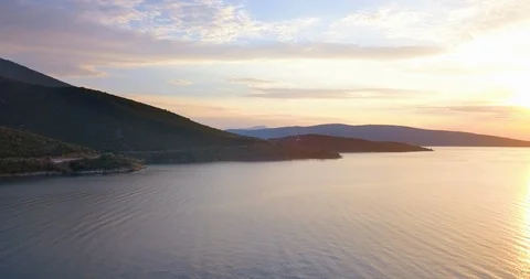 Hilly coastline at orange colored sunset Stock Footage 107962829