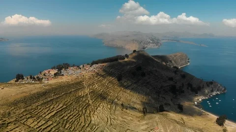 Hilly dry landscape of Isla del Sol surrounded by blue water of Lake Titicaca Stock Footage 124510565