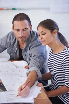 With him teaching her she would learn fast. a man and young woman discussing Stock Photos