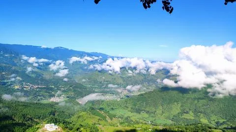 Himalayan valley with clouds rolling over green mountains 스톡 사진