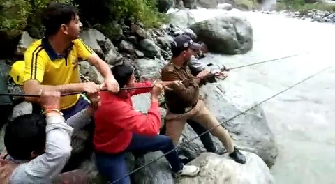 In the Himalayas, a rescue worker zip lined across a flooded river to pull ou... Video stock 106308770