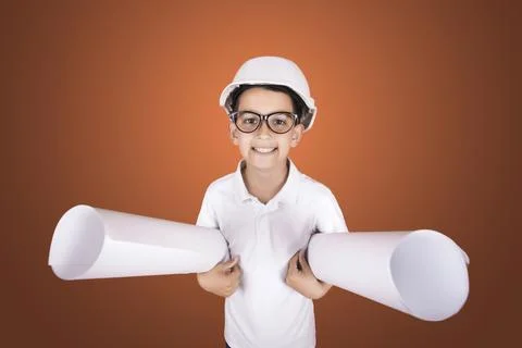 Hindu boy engineer in a hard hat and glasses with blueprints on a blue Stock Photos