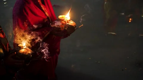 Hindu devotee holding diya during chhath puja ritual at riverbank 스톡 동영상 316802668