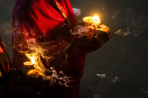 Hindu devotee holding diya during chhath puja ritual at riverbank Foto stock